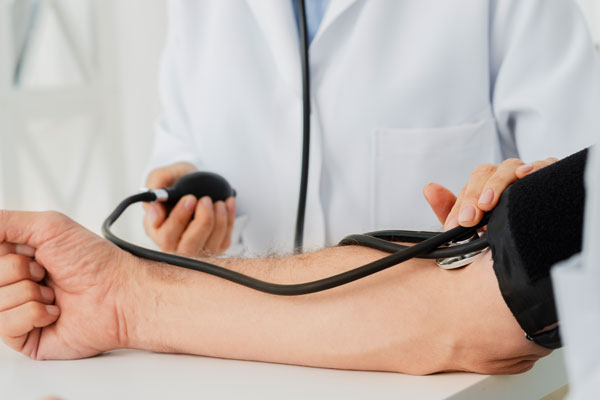 Врач измеряет пациенту артериальное давление перед раскодировкой от алкоголя